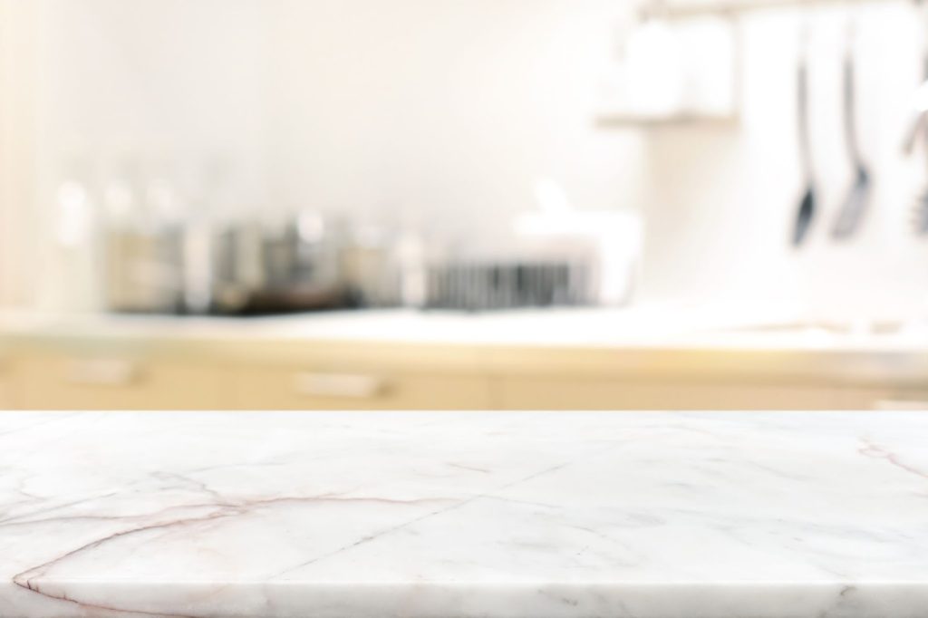A close up image of a marble countertop with an out of focus background.