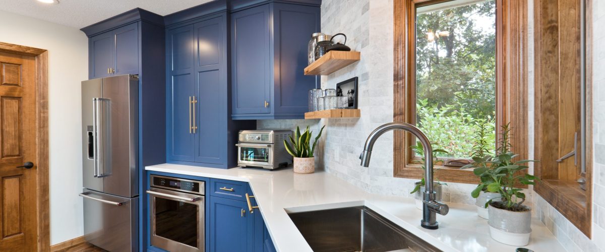 A contemporary kitchen renovation remodeling featuring a hardwood floor  kitchen sink, appliances and quartz counter top.